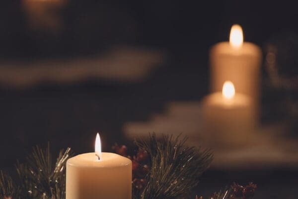 white pillar candle on brown wooden table